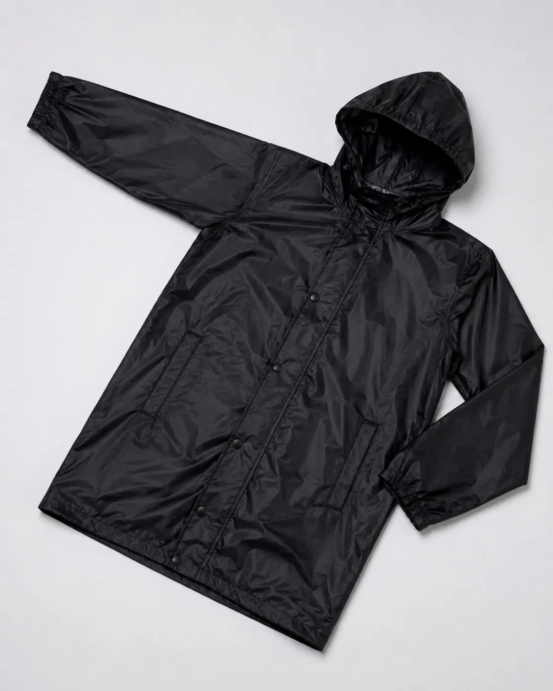 Black hooded rain jacket with snap closure, elastic cuffs, and pockets—water-resistant shell for B2B rainwear export from India